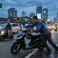 Ilustrasi seorang pria sedang mendorong motornya yang mogok. (AI)