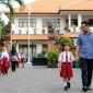 Ilustrasi seorang ayah mengantar anaknya ke sekolah.