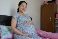 Seorang ibu hamil sedang menunjukkan kondisi kehamilannya. (Satuteks.com)