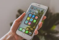 Tampilan jarak dekat sebuah tangan yang memegang iPhone. (Foto: Pexels)