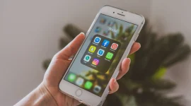 Tampilan jarak dekat sebuah tangan yang memegang iPhone. (Foto: Pexels)