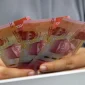 Ilustrasi seseorang sedang memegang uang rupiah. (Foto: Pexels)