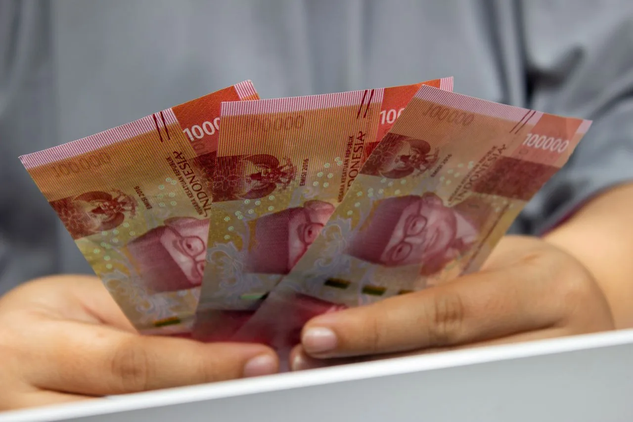 Ilustrasi seseorang sedang memegang uang rupiah. (Foto: Pexels)