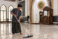 Seorang marbot sedang membersihkan masjid. (AI)
