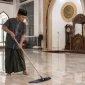 Seorang marbot sedang membersihkan masjid. (AI)