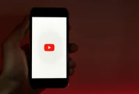Seseorang memegang ponsel pintar yang menampilkan aplikasi YouTube. (Pexels)