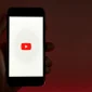 Seseorang memegang ponsel pintar yang menampilkan aplikasi YouTube. (Pexels)