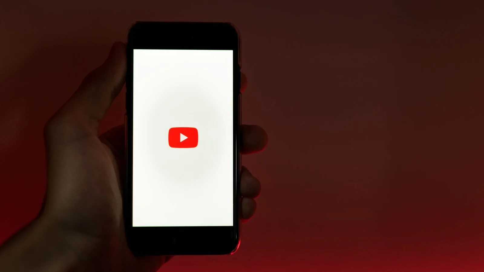 Seseorang memegang ponsel pintar yang menampilkan aplikasi YouTube. (Pexels)