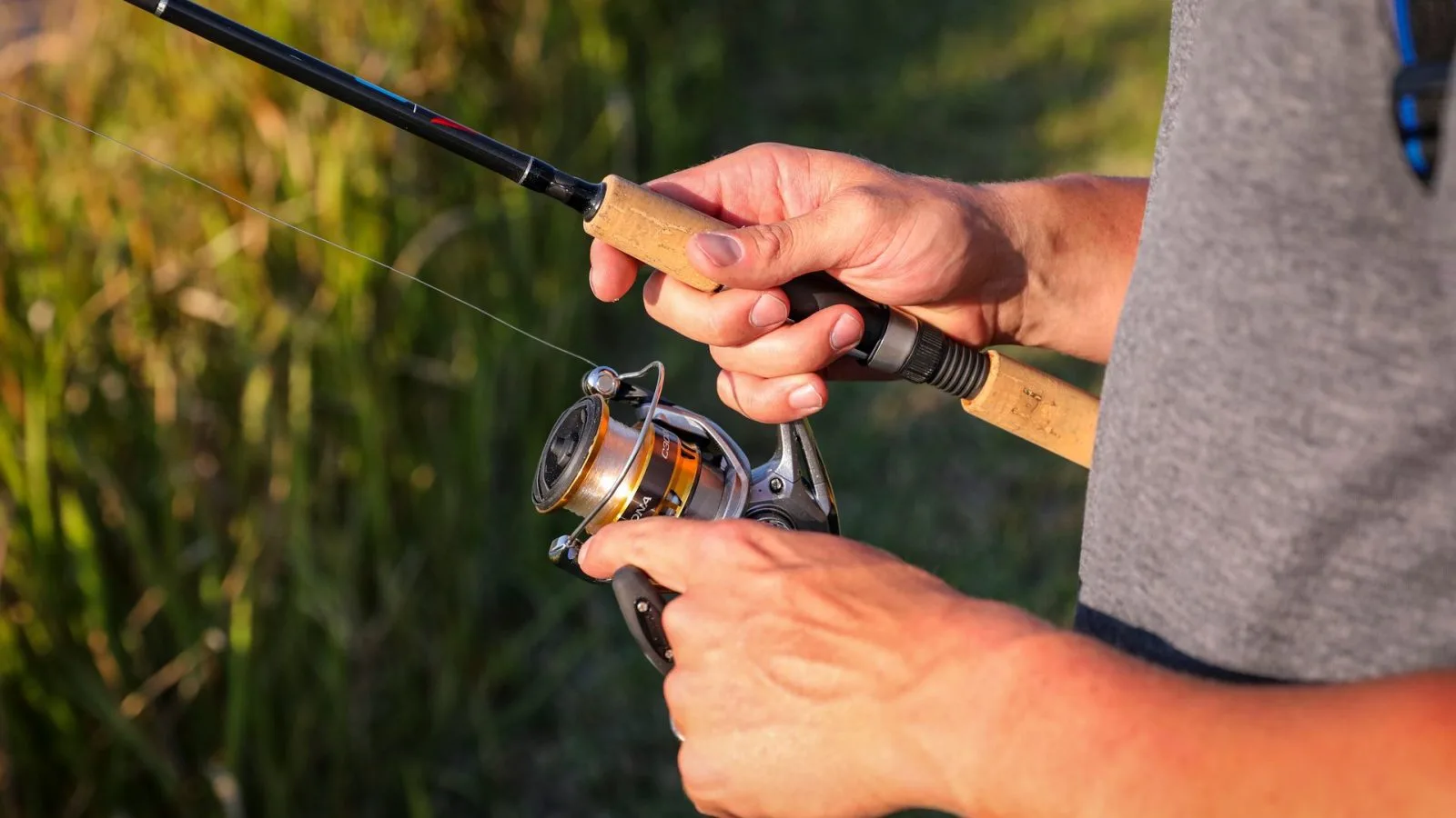 Tampilan detail tangan yang memegang joran pancing. (Foto: Pexels)
