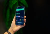 Seseorang memegang ponsel pintar yang menampilkan grafik  perdagangan saham. (Foto: Pexels)