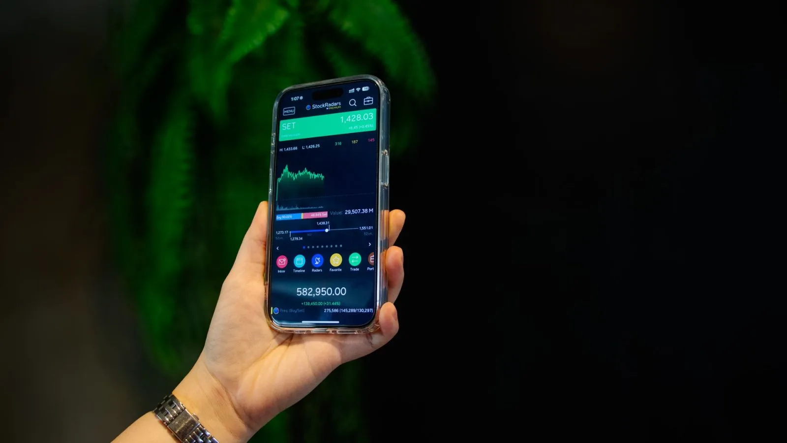 Seseorang memegang ponsel pintar yang menampilkan grafik  perdagangan saham. (Foto: Pexels)